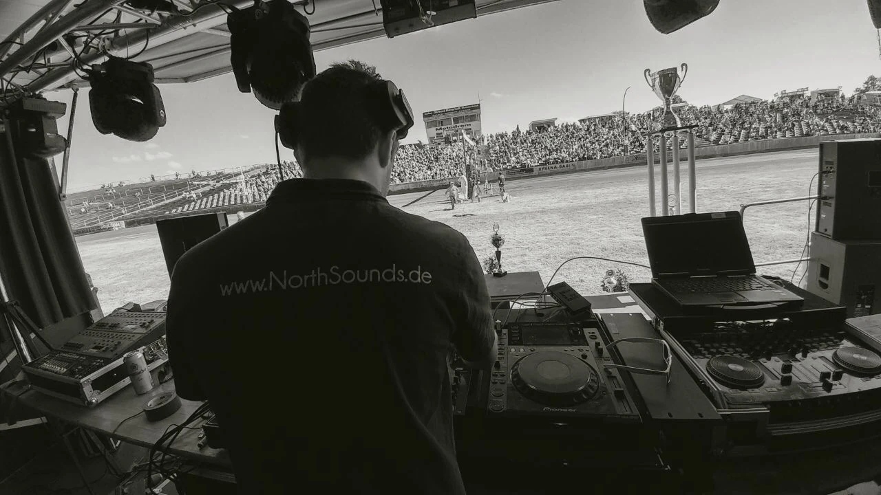 DJ im North Sounds Shirt hinter dem Pult bei einer Open-Air-Veranstaltung.