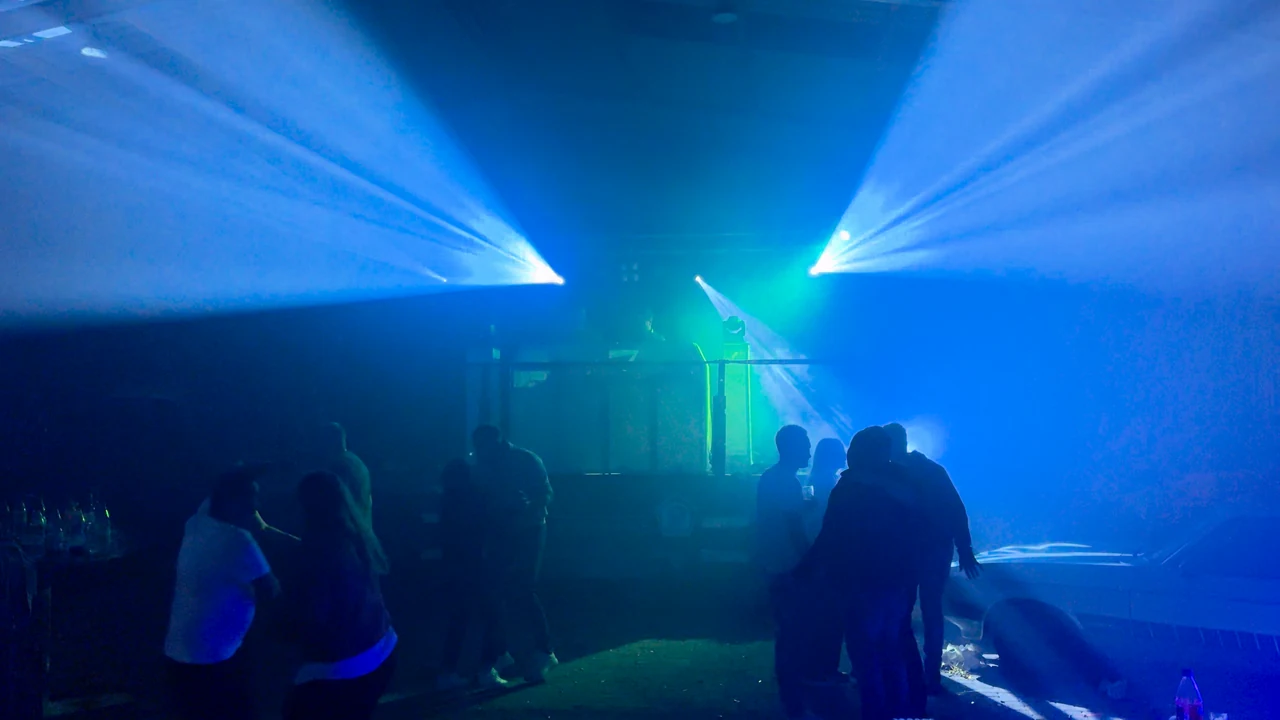 Gäste auf einer Tanzfläche im blauen Bühnenlicht.